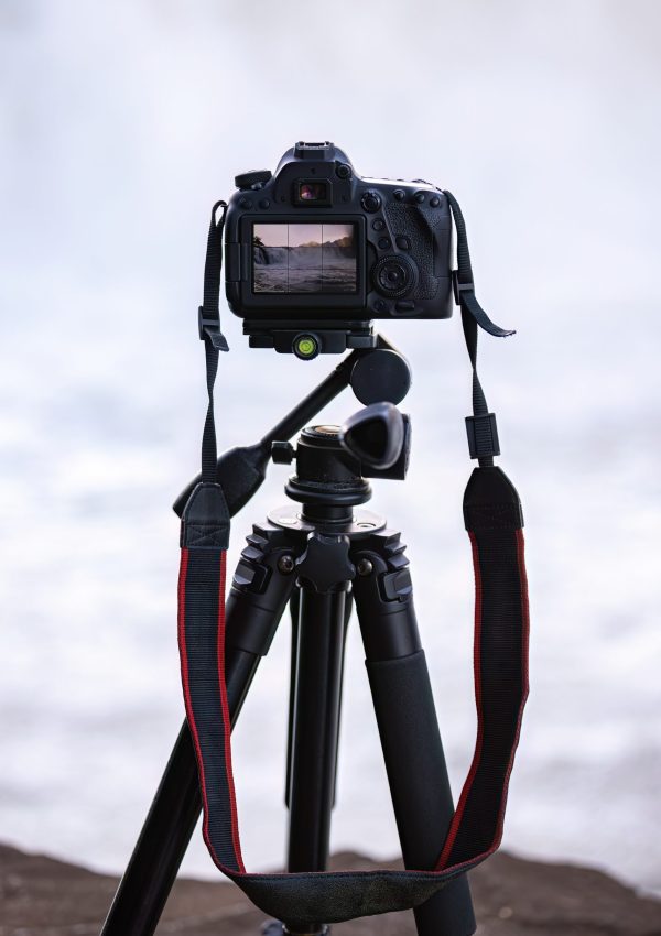 close up of photo camera on tripod to photograph a waterfall selective focus
